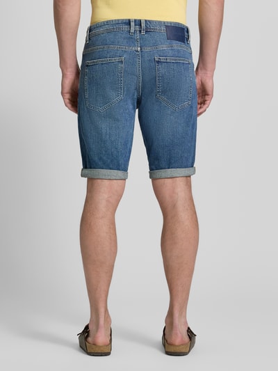 Männermodel trägt Regular Fit Jeans Bermudas aus Baumwoll-Mix von Tom Tailor in Denim-Optik mit Label-Patch, 5-Pocket-Design, Ganzkörperansicht Rückansicht.