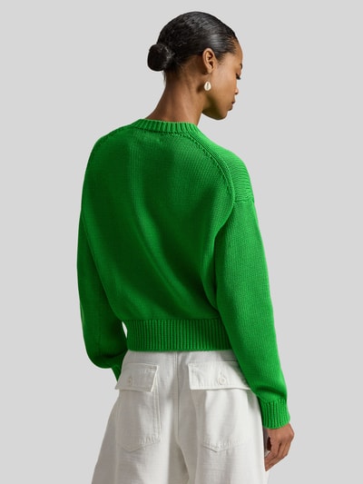 Frauenmodel trägt Regular Fit Strickpullover aus reiner Baumwolle von Polo Ralph Lauren, Two Tone Optik, gerippte Abschlüsse, Ganzkörperansicht Rückansicht.