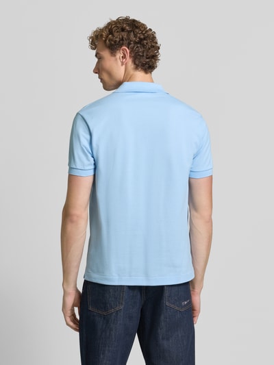 Männermodel trägt Regular Fit Poloshirt aus reiner Baumwolle von Lacoste in Hellblau, glatte Struktur, ganzkörperansicht rückansicht, Herren Poloshirt von Lacoste.