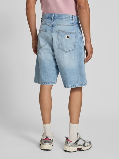 Männermodel trägt Loose Fit Jeansshorts im 5-Pocket-Design Modell 'Brandon' von Carhartt Work In Progress aus Reine Baumwolle, hellblau mit sichtbaren Nähten, Innenbeinlänge bei Größe S: 25 cm, Bundweite: 40 cm, Ganzkörperansicht Rückansicht.
