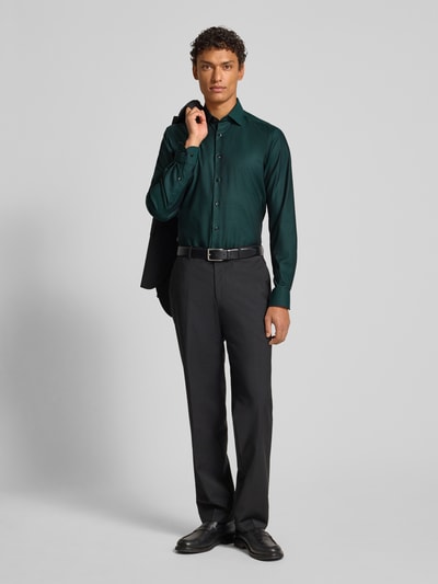 Männermodel trägt dunkelgrünes Slim Fit Business-Hemd mit Kentkragen von OLYMP Level Five, Baumwoll-Elasthan-Mix, Ganzkörperansicht von vorne.