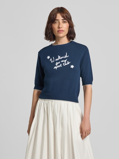 Frauenmodel trägt Regular Fit Strickshirt aus Baumwoll-Mix Modell 'WKDFIACRE' von Weekend Max Mara, dunkelblau mit weißem Schriftzug, glatte Textur, Damen Strickshirt von Weekend Max Mara, Nahaufnahme Oberkörper.