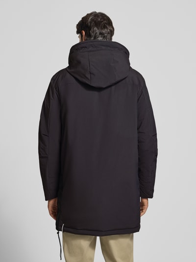 Männermodel trägt Jacke mit Pattentaschen Modell 'KADEN' von khujo in Schwarz, Regular Fit, mit Kapuze, verdecktem Reißverschluss und Label-Detail, Ganzkörperansicht Rückansicht.