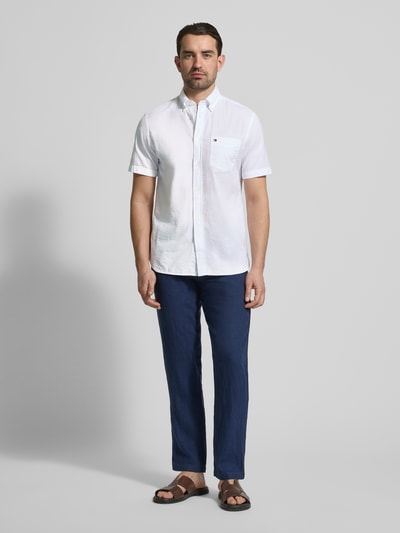 Männermodel trägt Regular Fit Freizeithemd aus reiner Baumwolle von Tommy Hilfiger in Optik: Unifarben, Logo-Stitching, Ganzkörperansicht von vorne.