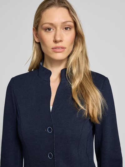 Modelka kobieca nosi Slim Fit Blazer mit Stehkragen von WHITE LABEL, mieszanka bawełny, krój slim fit, stójka, nakładane kieszenie, taliowany krój, listwa guzikowa, długość tyłu w rozmiarze 36: 62 cm, szerokość w rozmiarze 36: 46 cm, długość rękawów 65 cm, kolor granatowy, gładka faktura, zbliżenie górnej części ciała