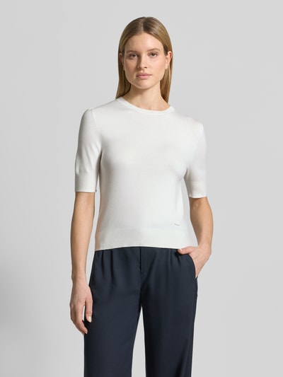 Vrouwenmodel draagt Slim Fit T-Shirt uit viscosemix van s.Oliver RED LABEL in gebreide look, kortemouw, fijngebreide textuur, label-applicatie, ronde hals, witte kleur, geribde randen, voorkant volledig lichaam.