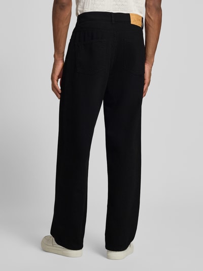Mężczyznamodel nosi czarne Loose Fit Jeans im 5-Pocket-Design Modell 'Roi' od Les Deux z bawełny, szerokie nogawki, całkowity widok z tyłu.