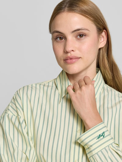 Kobiece modelka nosi bluzkę koszulową Oversized Hemdbluse aus reiner Baumwolle Modell 'BOSTATTA' od BOSS Orange, efekt: wzór w paski, krój oversized, kołnierzyk koszulowy, wyhaftowane logo, pas na plecach z kontrafałdą, listwa guzikowa, długi rękaw z mankietem, wykończenie zaokrąglone, bawełna, zbliżenie górnej części ciała