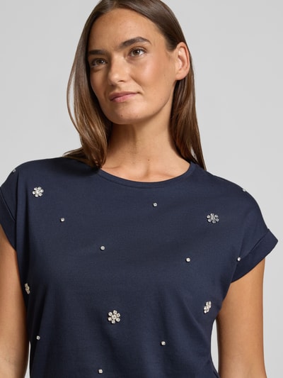 Frauenmodel trägt T-Shirt mit Ziersteinbesatz und Rundhalsausschnitt von Christian Berg Woman in Dunkelblau, Nahaufnahme Oberkörper, reine Baumwolle, Regular Fit.
