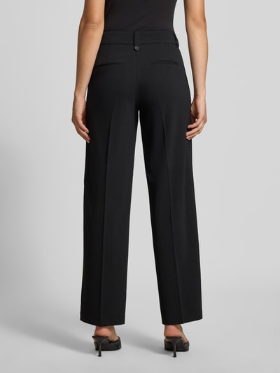 Frauenmodel trägt Regular Fit Weite Hose mit Bügelfalten Modell 'KALINA' von ONLY, schwarze Farbe, glatte Stofftextur, Ganzkörperansicht Rückansicht, Damen Weite Hose von ONLY.