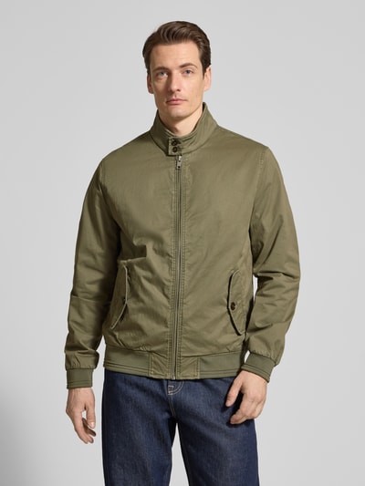 Männermodel trägt Jacke mit Stehkragen und Pattentaschen von Christian Berg Men, Baumwoll-Elasthan-Mix, Regular-Fit, oliv, Ganzkörperansicht von vorne. Rückenlänge bei Größe M: 32 cm, Schulterbreite: 41 cm, Brustweite: 55 cm, Ärmellänge: 67 cm, Reißverschluss, strukturierte Oberfläche.