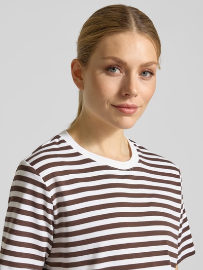 Modelka kobieca nosi T-Shirt im Allover-Look mit Rundhalsausschnitt od comma, bawełna z domieszką elastanu, krój regular fit, wzór paski, dekolt okrągły, długość tyłu w rozmiarze 36: 53 cm, zbliżenie na górną część ciała.