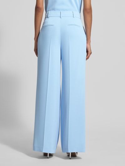 Frauenmodel trägt Wide Fit Stoffhose mit Bügelfalten von Christian Berg Cocktail in Hellblau, Gesäßtaschen, Ganzkörperansicht Rückansicht.