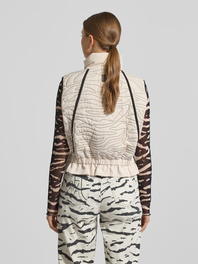 Frauenmodel trägt Weste mit Zweiwege-Reißverschluss von Marc Cain in Beige mit Ziernähte, lockerer Schnitt, Stehkragen, Rückenlänge 51 cm, Schulterbreite 40 cm, Brustweite 43 cm, Ganzkörperansicht Rückansicht.