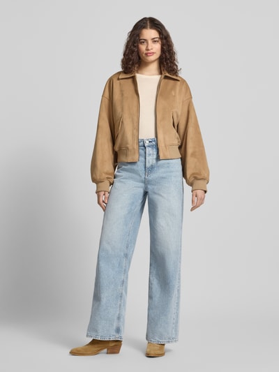Vrouwenmodel draagt Wide Leg Jeans uit katoenmix van Tommy Jeans in licht denim met high waist, label patch en 5-pocket-design, full body aanzicht van voren.