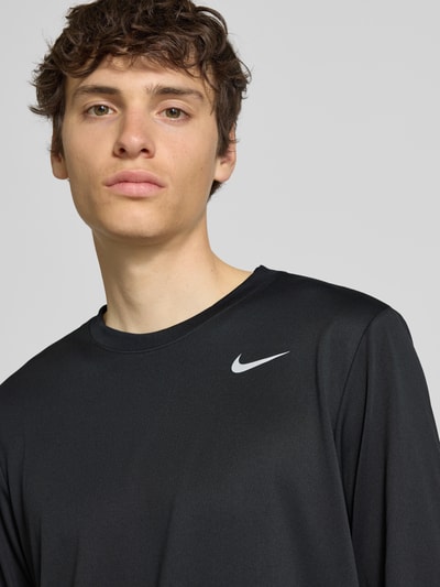 Mężczyzna prezentuje Longsleeve mit Logo-Print und Rundhalsausschnitt von NIKE TRAINING, krój straight fit, jednolity kolor, długość pleców w rozmiarze M: 70 cm, zbliżenie na górną część ciała