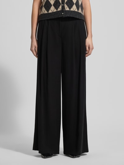 Frauenmodel trägt Hose aus Viskose-Mix mit weitem Bein von MAC, Schwarz, Gelegte Falten, Gesäßtaschen, Nahaufnahme Vorderansicht.