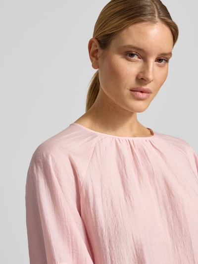 Kobiece modelka nosi Blusenshirt mit Raglanärmeln Modell 'Fibiza' od OPUS, lyocellowa mieszanka, luźny krój, jasnoróżowy kolor, okrągły dekolt, tekstura marszczona, widok z przodu, zbliżenie na górną część ciała.