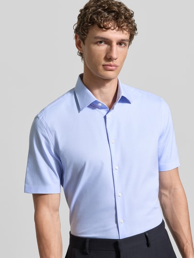 Männermodel trägt Slim Fit Business-Hemd mit Kentkragen von Jake*s, Baumwoll-Mix mit Stretch-Anteil, Knopfleiste, Nahaufnahme Oberkörper.