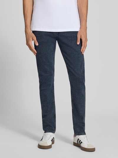 Männermodel trägt dunkelblaue Tapered Fit Jeans aus Baumwoll-Mix Modell 'EVEREST' von Calvin Klein Jeans, Nahaufnahme Unterkörper, Herren Tapered Fit Jeans von Calvin Klein Jeans.
