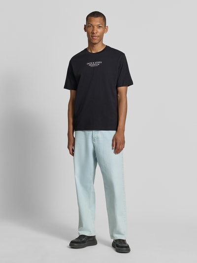 Männermodel trägt T-Shirt mit Label-Print und Rundhalsausschnitt von JACK & JONES aus reiner Baumwolle, Regular Fit, Ganzkörperansicht von vorne.