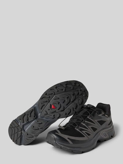 Produktfoto, Sneaker mit profilierter Sohle Modell 'XT-EVR' von Salomon, abgerundete Spitze, schwarze Farbnuancen, Textil- und Synthetikstruktur, Logo, Damenschuh mit 4 cm Absatz, 6 cm Schafthöhe und 7 cm Schaftweite