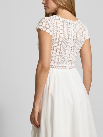 Kobiece modelka nosi Brautkleid mit floraler Spitze od LUXUAR FASHION, białe, gładkie, z kwiatową koronką, dopasowany krój, rozkloszowana spódnica, widok całej sylwetki z tyłu.