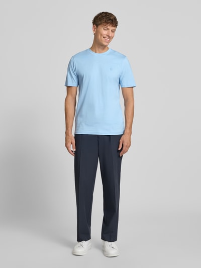 Męski model nosi Regular Fit T-Shirt mit Logo-Stitching von MCNEAL z bawełny, okrągły dekolt, długość tyłu 70 cm w rozmiarze M, kolor jasnoniebieski, gładka faktura, Ganzkörperansicht von vorne.