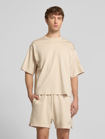 Männermodel trägt Regular Fit T-Shirt aus reiner Baumwolle von adidas Sportswear, Optik: Unifarben, Logo-Print, Jersey, Ganzkörperansicht von vorne.