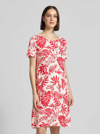 Vrouwenmodel draagt Relaxed Fit jurk uit viscosemix model 'Tara' van ZABAIONE, rood-wit bladmotief, ronde hals, korte mouwen, vooraanzicht bovenlichaam.