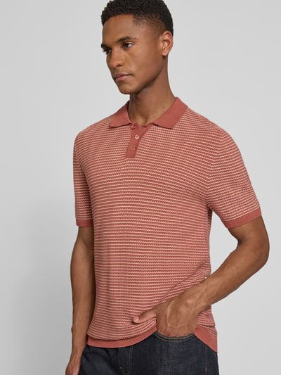 Männermodel trägt Slim Fit Strick-Poloshirt in Two-Tone-Machart Modell 'Triton' von Drykorn aus reiner Baumwolle; Nahaufnahme Oberkörper.