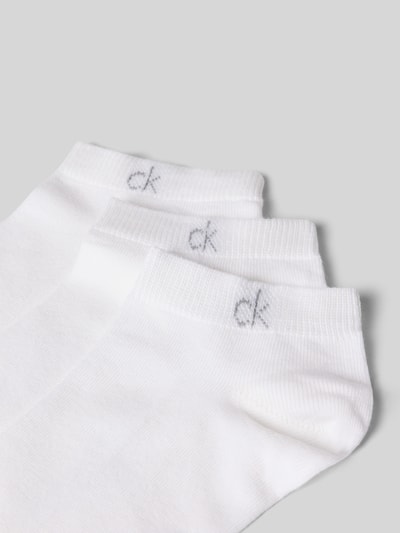 Produktfoto, drei weiße Socken aus Baumwoll-Mix im 3er-Pack von CK Calvin Klein, feine Struktur vor grauem Hintergrund.