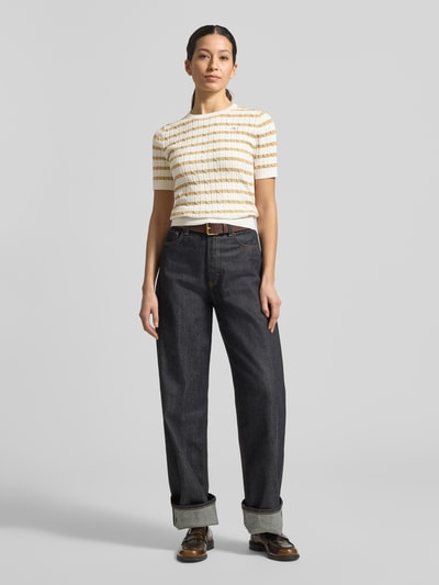 Frauenmodel trägt Strickshirt mit Rundhalsausschnitt und Label-Stitching von Gant, cremefarben mit gelben Streifen, Ripp-Optik, Baumwoll-Mix, Ganzkörperansicht von vorne.