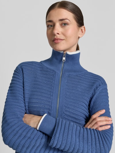 Frauenmodel trägt Strickpullover mit Reißverschluss Modell 'morwenna' von VARLEY aus Reine Baumwolle, Regular-Fit, Stehkragen, Nahaufnahme Oberkörper.