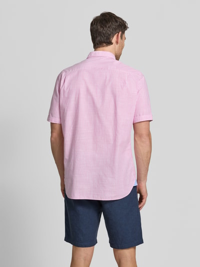 Männermodel trägt Regular Fit Freizeithemd mit Brusttasche von Christian Berg Men in Rosa-Weiß mit feinen Streifen, Kurzärmelig, Rückenansicht. Reine Baumwolle, Button-Down-Kragen, durchgängige Knopfleiste, Rückenlänge 79 cm, Schulterbreite 47 cm, Ärmellänge 26 cm.