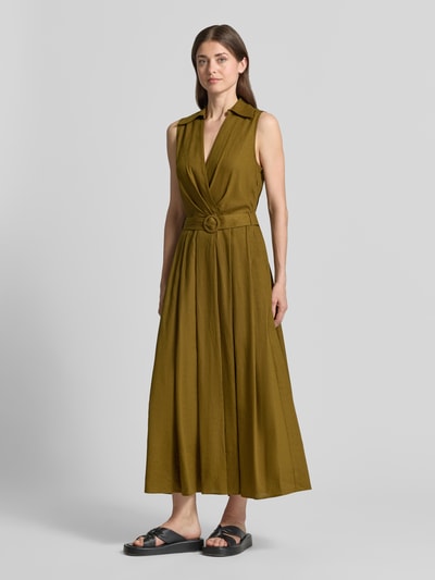 Frauenmodel trägt Maxikleid aus Leinen-Viskose-Mix mit Gürtel von Stefanel in Olivgrün, taillierter Schnitt, Wickel-Optik, Hemdblusenkragen, Ganzkörperansicht von vorne.