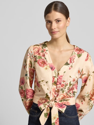 Frauenmodel trägt Cropped Bluse aus Leinen-Viskose-Mix Modell 'SHIRLEY' von Guess mit floralem Muster, V-Ausschnitt, Knopfleiste, Damen Bluse, Nahaufnahme Oberkörper.