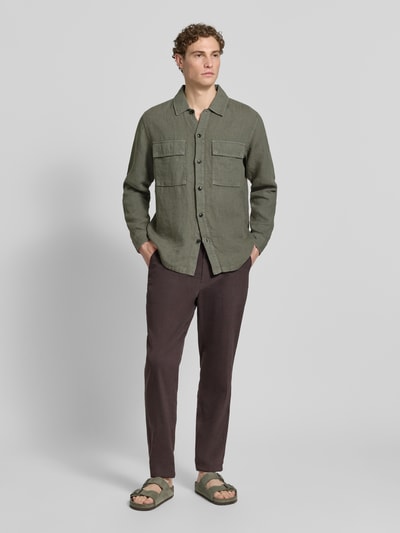 Männermodel draagt Relaxed Fit vrijetijdsoverhemd uit puur linnen model 'LOCKY' van BOSS Orange in effen kleuren met kentkraag, doorlopende knoopsluiting, labelpatch, borstzakken, gevlamd garen; materiaal: linnen. Ganzkörperansicht van voren.