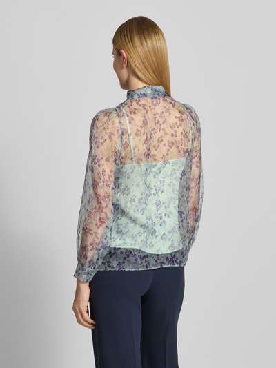 Vrouwenmodel draagt Regular Fit strikblouse uit zuiver zijde met all-over look en semi-transparante look van Marc Cain, ruglengte maat 36: 63 cm, mouwlengte maat 36: 61 cm, geheelzicht achterkant.