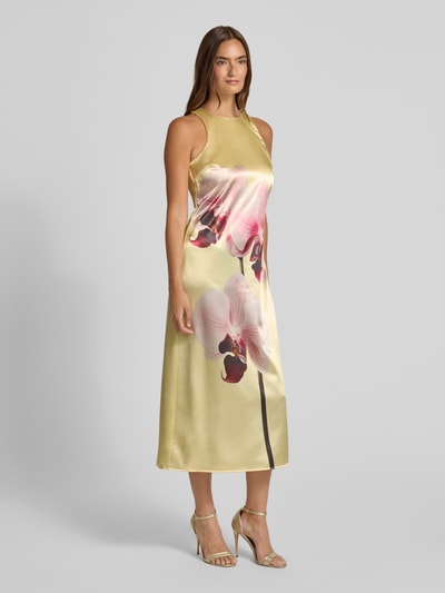 Frauenmodel trägt Cocktailkleid aus Satin mit Motiv-Print von YAS, A-Linie, Midikleid, Rundhalsausschnitt, Ganzkörperansicht von vorne.