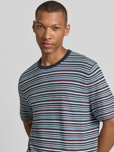 Męski model nosi T-Shirt mit Rundhalsausschnitt von MCNEAL, bawełna, krój regular fit, granatowe i niebieskie paski, długość tyłu 70 cm, długość rękawa 25 cm, zbliżenie na górną część ciała
