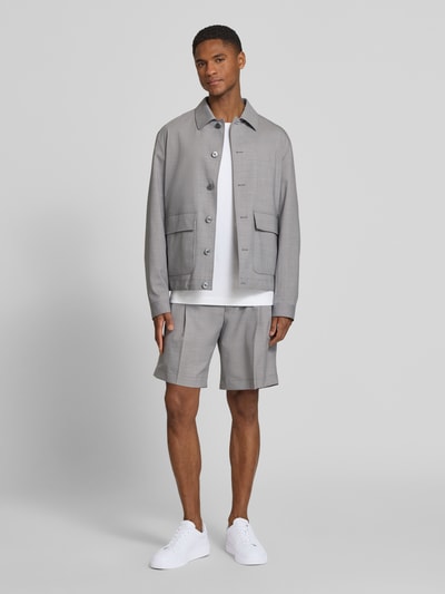 Männermodel trägt Regular Fit Hemdjacke aus Woll-Mix mit Kentkragen von bugatti in Hellgrau, große Pattentaschen, Ganzkörperansicht von vorne.