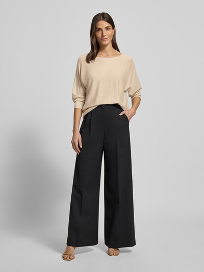 Frauenmodel trägt Relaxed Fit Pullover aus Viskose-Mix in Strick-Optik von Comma in Glitzer-Optik, U-Boot-Ausschnitt, 3/4-Arm, Ganzkörperansicht von vorne.
