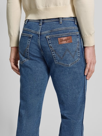 Männermodel trägt Straight Fit Jeans im 5-Pocket-Design Modell 'Texas' von Wrangler, blauer Baumwoll-Mix, detailreiche Rückansicht.