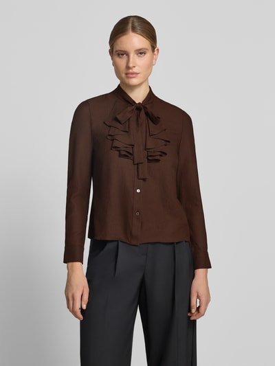 Frauenmodel trägt Regular Fit Schluppenbluse mit Rüschen von Christian Berg Woman Selection in Braun mit Knopfleiste, Nahaufnahme Oberkörper.