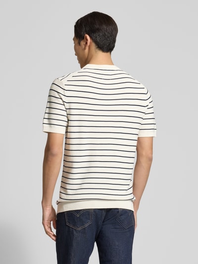 Männermodel trägt Strickshirt mit geripptem Rundhalsausschnitt von MCNEAL, Reine gewachste Baumwolle, Gerader-Schnitt, Gerippte-Abschlüsse, Rückenlänge 72 cm, Ärmellänge 25 cm, Creme mit dunklen Streifen, Ganzkörperansicht Rückansicht.