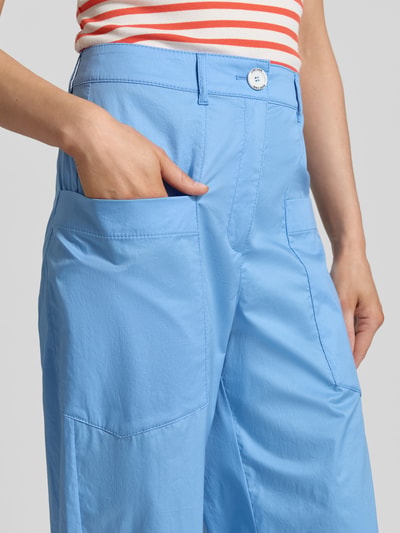 Frauenmodel trägt Wide Fit Stoffhose mit aufgesetzten Taschen von Marc Cain, hellblauer Baumwoll-Mix, Nahaufnahme Oberkörper.