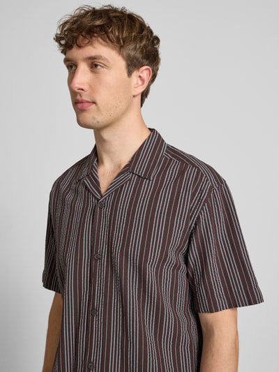 Männermodel trägt Relaxed Fit Freizeithemd aus reiner Baumwolle Modell 'CRUZ' von Only & Sons mit Streifenmuster, Nahaufnahme Oberkörper.
