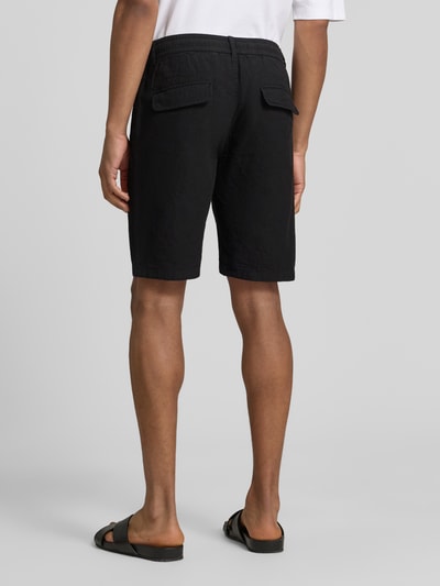 Männermodel trägt Bermudas aus Leinen-Mix mit französischen Eingrifftaschen von Lindbergh, mieszanka lnu i bawełny, krój straight fit, elastyczny pas z trokiem, zapięcie na guzik i zamek błyskawiczny, wpuszczane kieszenie, kieszenie z tyłu, szerokość w rozmiarze M: 43 cm, długość wewnętrzna nogawki w rozmiarze M: 24 cm, czarny kolor, tekstura gładka, Ganzkörperansicht Rückansicht.