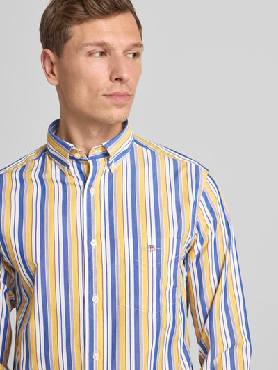 Männermodel draagt Vrijetijdsoverhemd met knoopsluiting van Gant in geel, blauw en wit, puur katoen, regular fit, borstzak, labelstitching, button-downkraag, knoopsluiting, ruglengte 77 cm, schouderbreedte 44 cm, mouwlengte 67 cm, Nahaufnahme Oberkörper.